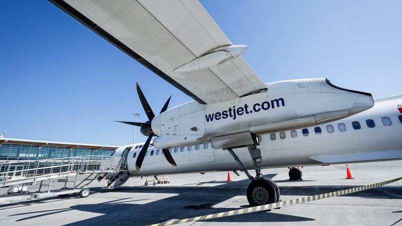 A WestJet Encore Bombardier Q400 twin-engined turboprop aircraft is prepared for a flight in Kamloops, Saturday, June 3, 2023. (THE CANADIAN PRESS/Jeff McIntosh)