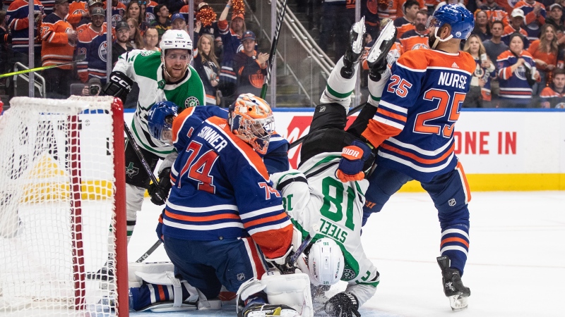 Dallas Stars forward Sam Steel is upended in front of the net as Edmonton Oilers defenceman Darnell Nurse stands guard and goalie Stuart Skinner makes the save during third-period action in Game 4 of the NHL Western Conference Final on May 29, 2024. (Jason Franson/The Canadian Press)
