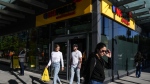 Customers walk out with their shopping from a new 'small format' No Frills grocery store, which the company is testing, in Toronto, Thursday, May 30, 2024. THE CANADIAN PRESS/Chris Young