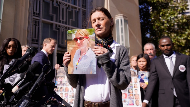 Catherine Berthet, of France, closes her eyes as she holds a photo of her deceased daughter Camille Geoffroy, in front of other families that lost loved ones to crashes of the Boeing 737 Max airliner outside the federal court in Fort Worth, Texas, Thursday, Jan. 26, 2023.(AP Photo/LM Otero, file)