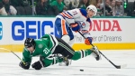 Dallas Stars winger Jason Robertson loses his footing while competing for the puck with Edmonton Oilers forward Ryan McLeod during Game 5 of the NHL Western Conference Final on May 31, 2024, in Dallas. (Tony Gutierrez/Associated Press)