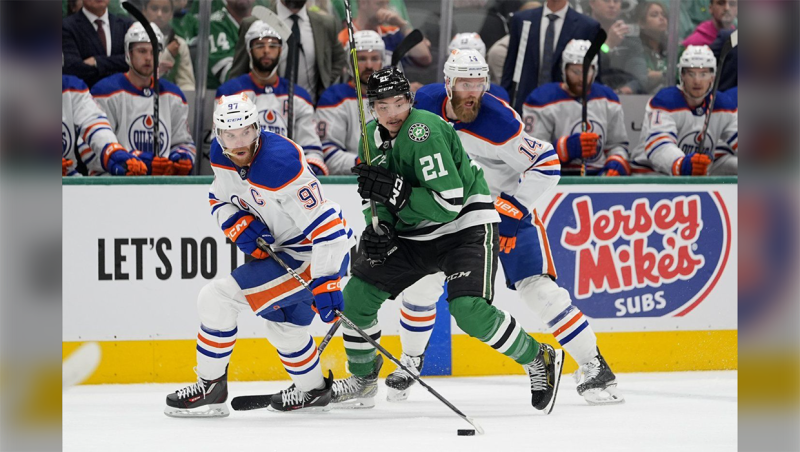 Edmonton Oilers center Connor McDavid (97) controls the puck in front of Dallas Stars left wing Jason Robertson (21) and Mattias Ekholm, right, during the first period of Game 5 of the Western Conference finals in the NHL hockey Stanley Cup playoffs Friday, May 31, 2024, in Dallas. (AP Photo/Julio Cortez)