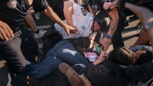 A New York City police officer punches a pro-Palestinian demonstrator as he pins him on the ground during a protest demanding a permanent cease-fire in Gaza, Friday, May 31, 2024, in the Brooklyn borough of New York. (AP Photo/Andres Kudacki)