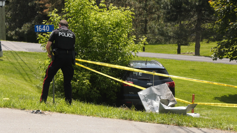 A police officer tapes off a portion of lawn. June 2, 2024 (Sam Houpt/CTV News Ottawa)