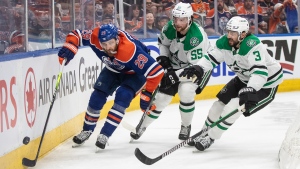 Dallas Stars defencemen Thomas Harley (55) and Christopher Tanev (3) battle for the puck with Edmonton Oilers centre Leon Draisaitl during Game 6 of the NHL Western Conference Final on June 2, 2024, in Edmonton. (Jason Franson/The Canadian Press)