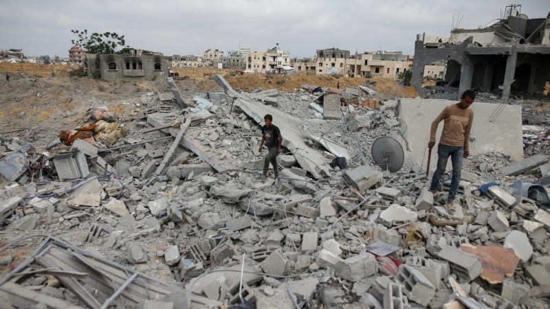 Palestinians look at the destruction after an Israeli airstrike in Khan Younis, Gaza Strip, Monday, June 3, 2024. (AP Photo/Jehad Alshrafi)