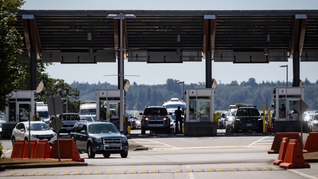 A Canada Border Services Agency officer is silhouetted as motorists enter Canada at the Douglas-Peace Arch border crossing, in Surrey, B.C., on Monday, August 9, 2021. THE CANADIAN PRESS/Darryl Dyck