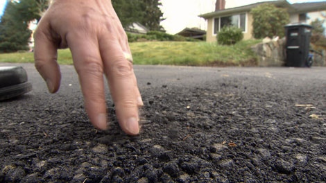 A light brush of the hand is enough to lift paving material from this driveway, re-surfaced only two weeks earlier. March 18, 2010. (CTV)