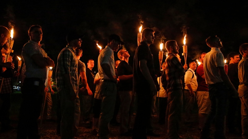 FILE - Multiple white nationalist groups march with torches through the University of Virginia campus on Aug. 11, 2017, in Charlottesville, Va. (Mykal McEldowney/The Indianapolis Star via AP, File)