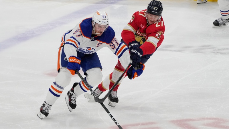Edmonton Oilers captain Connor McDavid, left, and Florida Panthers forward Eetu Luostarinen during NHL action on Nov. 20, 2023, in Sunrise, Fla. (Marta Lavandier/Associated Press)