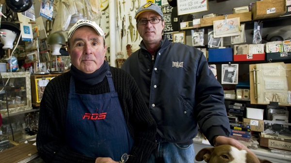 Abraham, left, and Ivan Botines with their dog Sasa pose for a photograph in their curiosity shop in Montreal, Friday, March 26, 2010 where they are selling a controversial bar of soap, allegedly made by the Nazi's with the remains of victims from the holocaust. (THE CANADIAN PRESS/Graham Hughes)