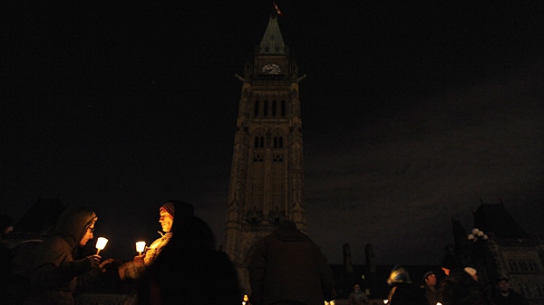 Karen Lapointe and Joey Marrocco hold candles as the lights go out on Parliament Hill in Ottawa on Saturday March 27, 2010 to celebrate Earth Hour. (Ashley Fraser / THE CANADIAN PRESS)