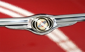 The Chrysler logo is shown on one of its cars at a dealership. (AP / Don Ryan) 