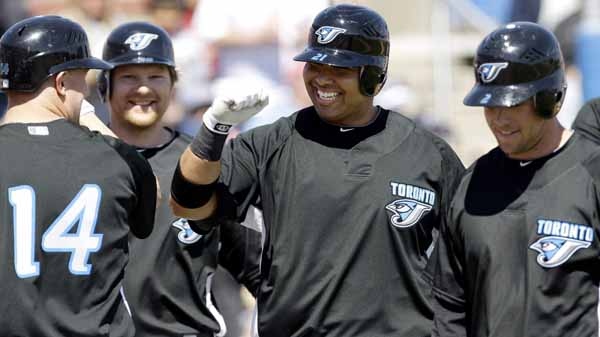 Toronto Blue Jays' Randy Ruiz, center, celebrates with teammates John Buck (14), Aaron Hill, right, and Adam Lind after he hit a grand slam against Detroit Tigers' Jeremy Bonderman during the first inning of a spring training baseball game, Sunday, March 7, 2010, in Dunedin, Fla. (AP Photo/Eric Gay)