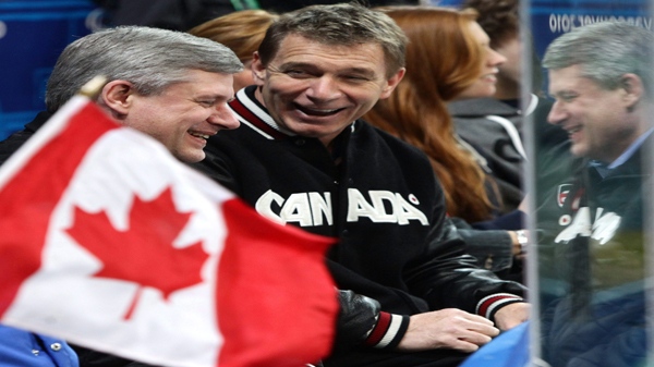 FILE-- Prime Minister Stephen Harper, left, sits with Canada's 'Man in Motion' Rick Hansen as Canada plays Norway during first period bronze medal ice sledge hockey action at the 2010 Winter Paralympics in Vancouver, B.C., on Friday March 19, 2010. (THE CANADIAN PRESS/Darryl Dyck)