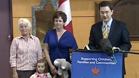 Military wife Anne Duquette, centre, joins  Conservative MP Pierre Poilievre for an announcement to extend parental leave for military families, Monday, April 5, 2010.
