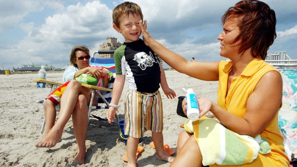 Bernadine Boyce, right, of Allentown, Pa., applies sunscreen to Bruno Barber, 5, of Atlantic City, as his mom, Natalia Barber, watches in Atlantic City, N.J., in this June 9, 2006, file photo. (AP Photo/Mary Godleski, File)