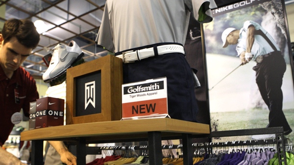 Sales Manager Andrew Lamoreaux adjusts Tiger Woods merchandise at a Golfsmith's store Wednesday, March 31, 2010 in New York. (AP / Frank Franklin II)
