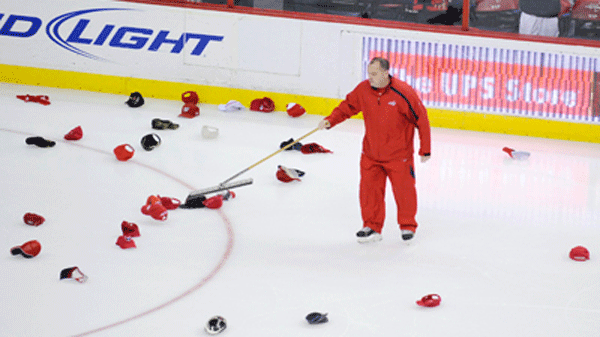 A worker sweeps caps from the ice after Washington Capitals center Nicklas Backstrom scored the game-winning goal against the Montreal Canadiens  during the overtime period of Game 2 of the NHL hockey playoffs, Saturday, April 17, 2010, in Washington. (AP Photo/Nick Wass)