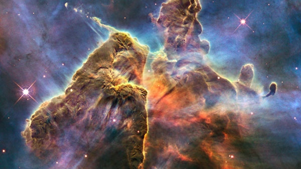 In this image provided by NASA, the Hubble Space Telescope captures the chaotic activity atop a three-light-year-tall pillar of gas and dust that is being eaten away by the brilliant light from nearby bright stars. (AP Photo/NASA)