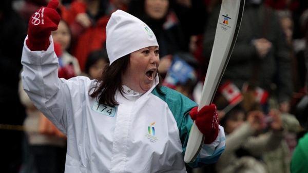 Jann Arden of Calgary carries the Olympic flame during the Olympic torch relay in Vancouver on Thursday, Feb. 11, 2010. (Darryl Dyck / THE CANADIAN PRESS)  