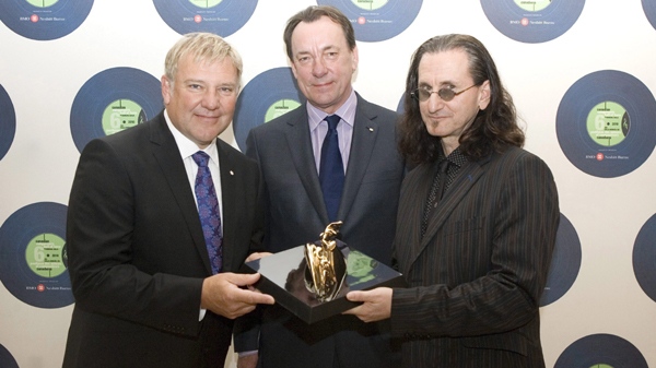 Alex Lifeson, left, Neil Peart, centre, and Geddy Lee of the band Rush pose with a trophy during a photo opportunity ahead of ceremony to induct them into the Canadian Songwriters Hall of Fame in Toronto on Sunday March 28, 2010. THE CANADIAN PRESS/Chris Young