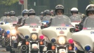 Police on motorcycles ride through central Toronto for a memorial to fallen officers on Sunday, May 2, 2010.