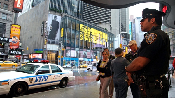 A New York City police officer stands watch on Times Square  as pedestrians pass by in New York, Monday, May 3, 2010. (AP / Craig Ruttle)