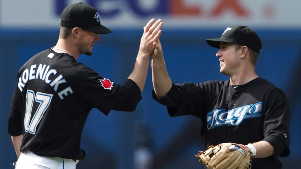 Toronto Blue Jays closing pitcher Josh Roenicke, left, celebrates with Blue Jays second baseman Aaron Hill, right, after defeating the Athletics 9-3 during ninth inning AL action in Toronto on Sunday, May 2, 2010. (THE CANADIAN PRESS/Nathan Denette)