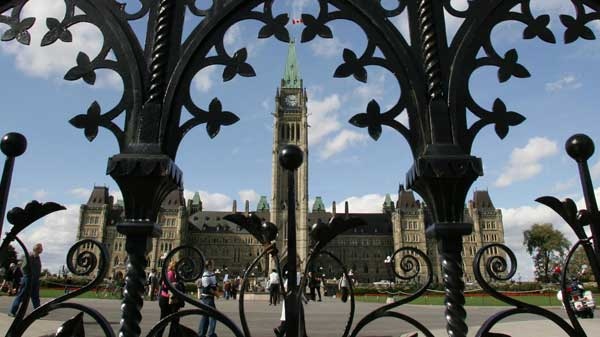 The Parliament buildings are framed through a fence on Parliament Hill in Ottawa Sunday, Oct. 3, 2004. (Jonathan Hayward / THE CANADIAN PRESS)