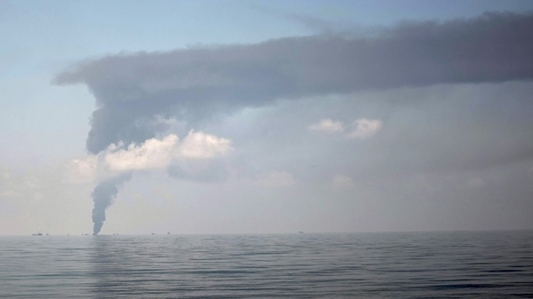 A plume of smoke is seen from a controlled oil burn from the deck of the Joe Griffin which, is carrying the containment vessel to be used to try to contain the Deepwater Horizon oil, at the rig collapse site, Thursday, May 6, 2010. (AP / Gerald Herbert)