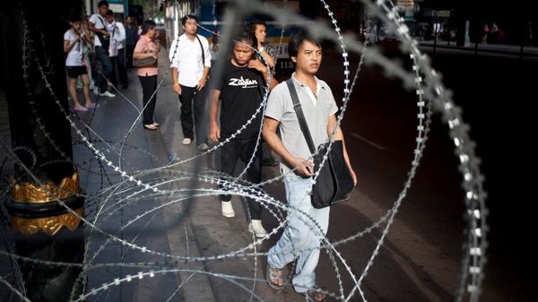 Residents walk past rows of razor wire in downtown Bangkok, Thailand Saturday, May 8, 2010. (AP / David Longstreath)
