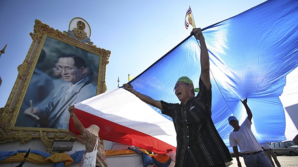 Pro-government supporters chant slogans with a Thai national flag in front of a portrait of King Bhumibol Adulyadej in Bangkok, Thailand, Sunday, May 9, 2010. (AP / Wally Santana)