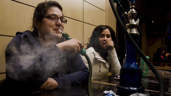 Christina Tsionas, 18, left, blows a cloud of smoke while enjoying a hookah with Aminah Rawdah, 18, at the Alexandria Cafe in the Toronto community of Scarborough, Saturday, May 8, 2010. (Darren Calabrese / THE CANADIAN PRESS) 