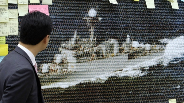 A man looks at a picture of the Cheonan naval ship comprised of portraits of the deceased sailors from the sunken ship, in Seoul, South Korea, Tuesday, May 4, 2010. (AP Photo /  Lee Jin-man)
