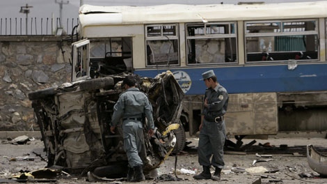 Afghan policemen look at the mangled remains of a vehicle after a suicide attack in Kabul, Afghanistan, Tuesday May 18, 2010. (AP Photo/Ahmad Massoud)