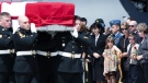 Mary Jane, the wife of Col. Geoff Parker, fourth from right, and their two children Alexandria, and Charlie, stand in front of her and watch the casket of Col. Geoff Parker at CFB Trenton on Friday, May 21, 2010.  (Nathan Denette / THE CANADIAN PRESS)