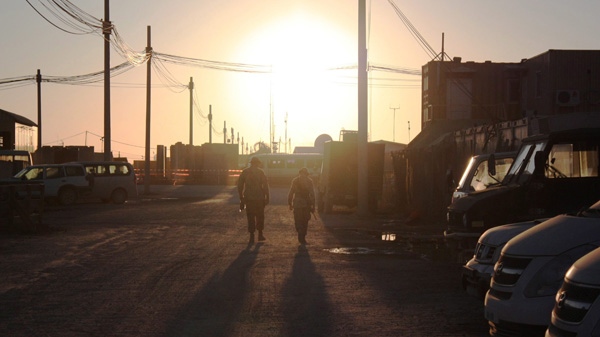 Two Canadian soldiers walk into the Christmas Day sunset at Kandahar Airfield in Afghanistan on Friday, Dec. 25, 2009. (Colin Perkel / THE CANADIAN PRESS)