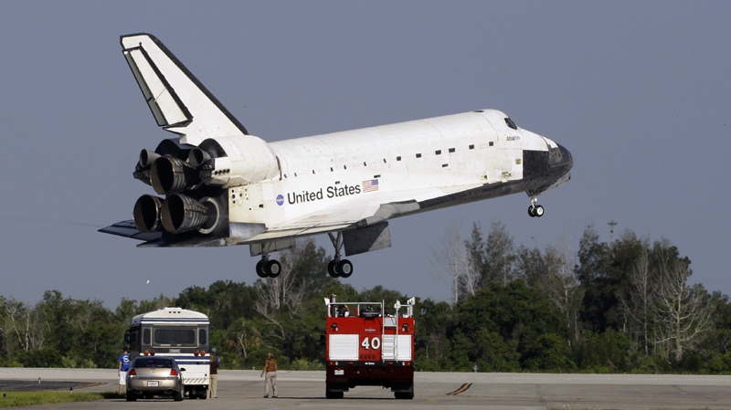 Space shuttle Atlantis glides by rescue vehicles before landing on Kennedy Space Center's runway 33 Wednesday, May 26, 2010 in Cape Canaveral, Fla. (AP Photo/Terry Renna)