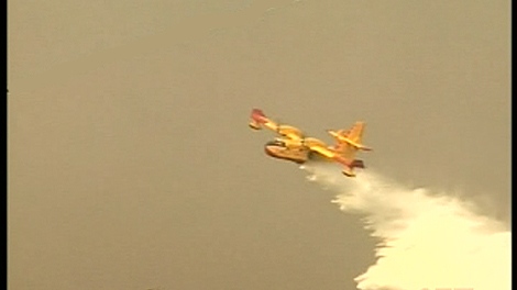 A water bomber flies over a forest fire near La Tuque, Quebec (May 27, 2010)