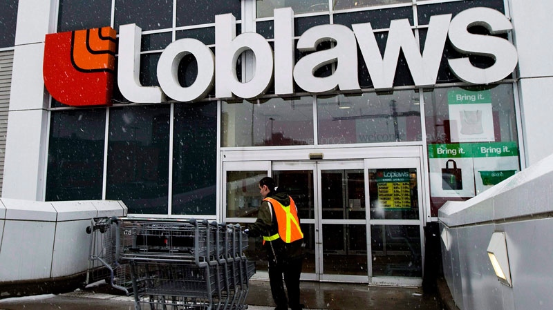 A Loblaws employee brings in shopping carts in Toronto on Wednesday, Feb. 18, 2009. (Nathan Denette / THE CANADIAN PRESS)