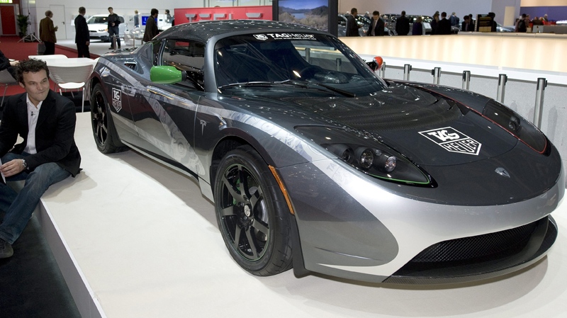 A visitor sits beside the 2010 TAG Heuer Tesla Roadster by Tesla at the Geneva Motor Show in Geneva, Switzerland, Wednesday, March 3, 2010. (AP / Martin Meissner)