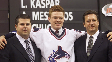 Cory Schneider, of Salem, Mass. is flanked by Vancouver Canucks Dave Nonis (left) and Steve Tambellini right after Schneider was selected 26th during the NHL draft in Raleigh, N.C. on Saturday June 26, 2004. (CP PHOTO/Chuck Stoody)