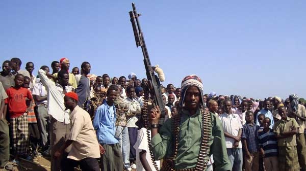 An fighter loyal to the Islamist insurgent group al Shabaab poses with his weapon in front of a crowd in Bulo Marer, Somalia, Saturday, Dec. 13, 2008. (AP / Farah Abdi Warsameh)
