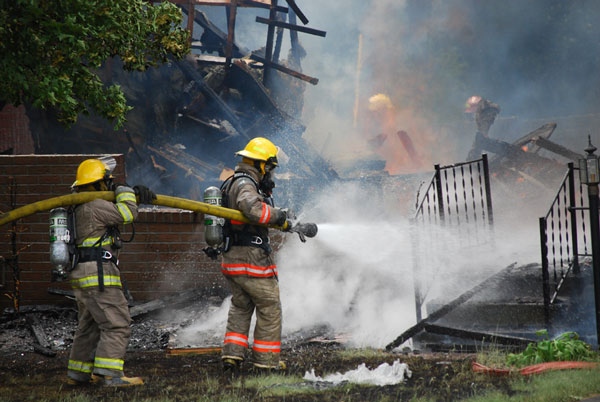 Firefighters work to put out a fire after a home exploded in Napanee, Monday, June 8, 2010. All that is left of the home are bricks and the front steps. Image courtesy: Seth DuChene, Napanee Beaver