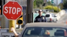 A U.S. Customs and Border Protection officer looks toward a car coming toward him at the border crossing between the U.S. and Canada, in Blaine, Wash. on Saturday, May 30, 2009. (Elaine Thompson/AP)