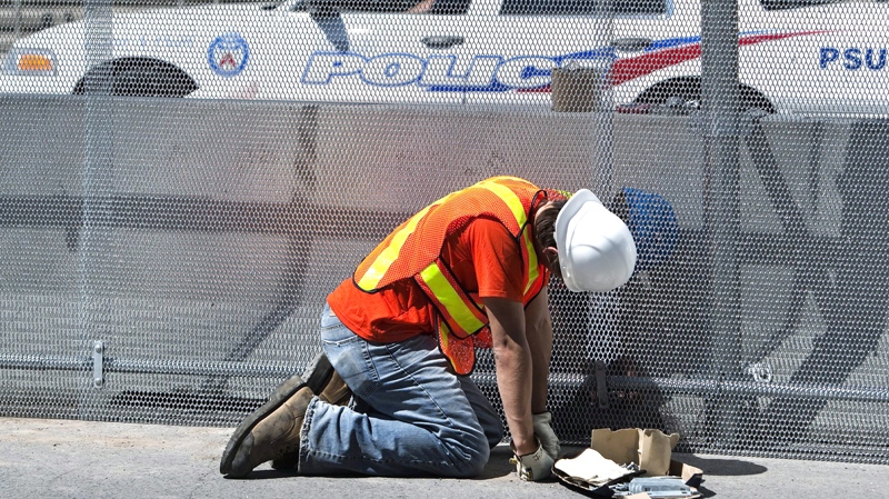 A construction worker puts up a three metre high steel security fence outside the Toronto Metro Convention Centre for the upcoming Toronto G20 summit in Toronto on Tuesday, June 8, 2010. (Nathan Denette / THE CANADIAN PRESS)