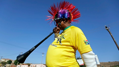 A man blows his vuvuzela on the street before the opening game of the soccer World Cup between South Africa and Mexico in Atteridgeville near Pretoria, South Africa, Friday, June 11, 2010. (AP Photo/Gero Breloer)