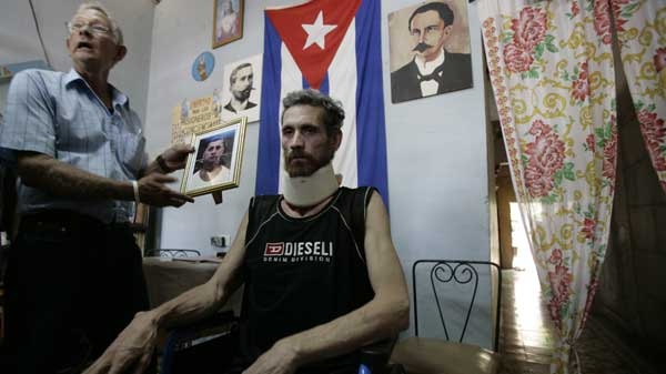 Ariel Sigler, an ailing political prisoner, right, listens while his brother Jose Sigler speaks with journalists after Ariel Sigler was released from a hospital where he was being held prisoner in Pedro Betancourt, Cuba, Saturday, June 12, 2010. (AP / Franklin Reyes)
