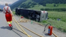  A fire fighter tears a hose near the site where a German Bus lying on its side near Reckingen, southwestern Switzerland, Saturday, June 12, 2010. (AP / Keystone/Urs Flueeler)